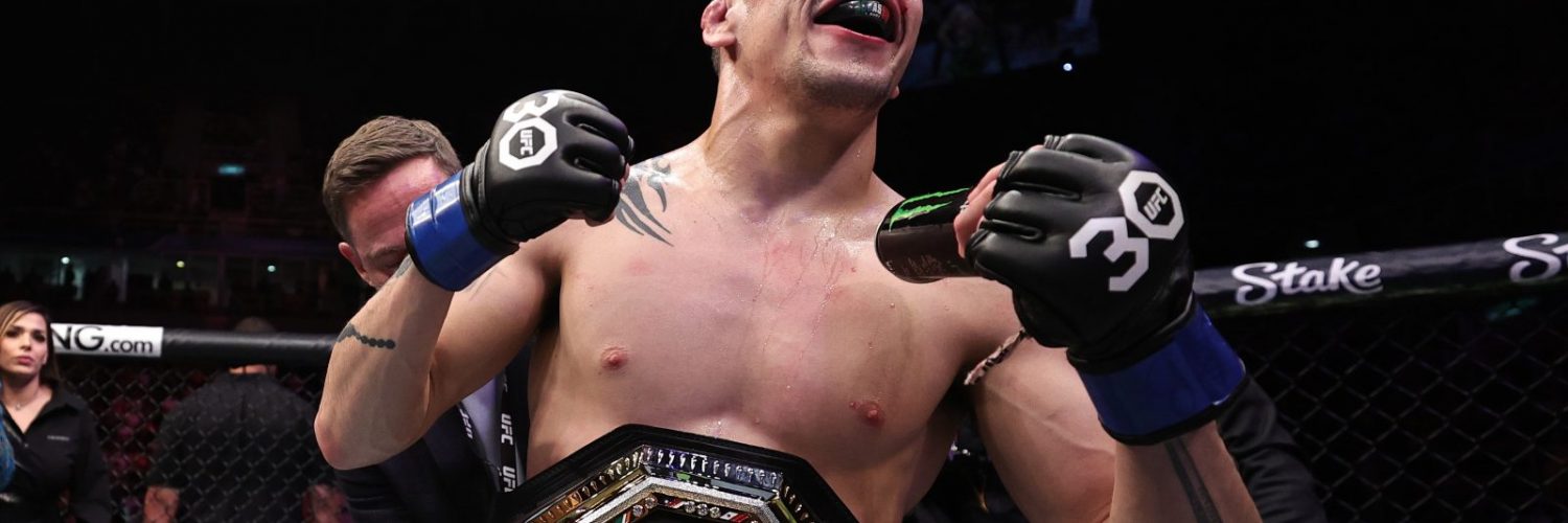 Brandon Moreno reacts after Brazilian fans pepper him with drinks following his title win at UFC 283