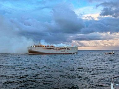 A freighter carrying nearly 3,000 cars catches fire in the North Sea and a crew member is killed